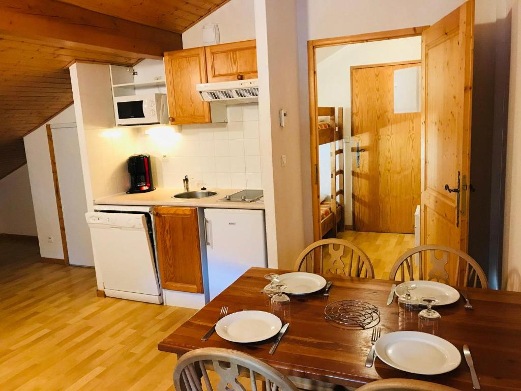 eine Küche und ein Esszimmer mit einem Holztisch und Stühlen in der Unterkunft Studio Samoëns, 1 pièce, 4 personnes - FR-1-629-92 in Samoëns