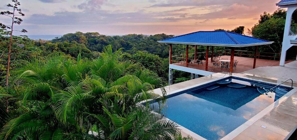 a house with a swimming pool and a gazebo at Villa Azul in Sámara