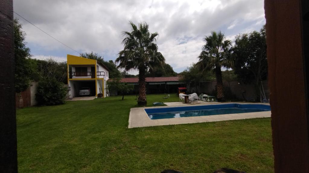a yard with a swimming pool and a house at Casafamiliar in Villa San Nicolás