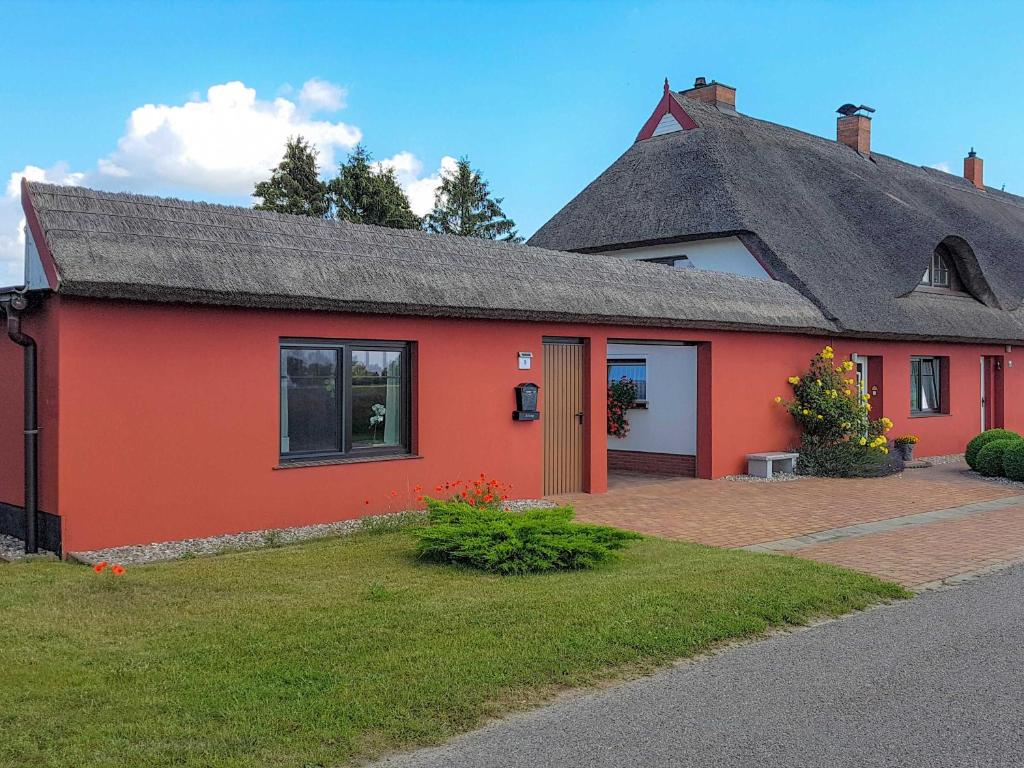 a red house with a gray roof at Ferienwohnung im roten Haus in Stahlbrode