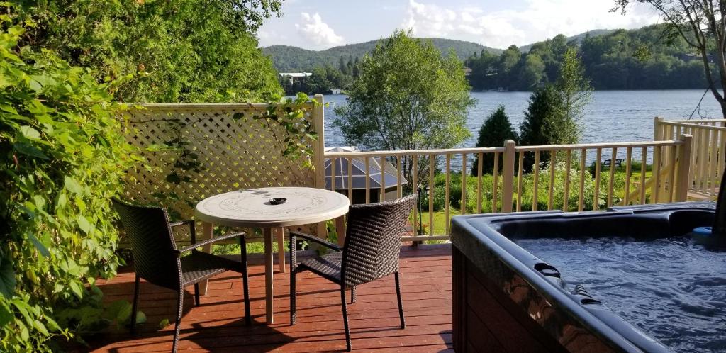 a patio with a table and chairs next to a hot tub at Auberge Aux Nuits de Rêve in Sainte-Agathe-des-Monts