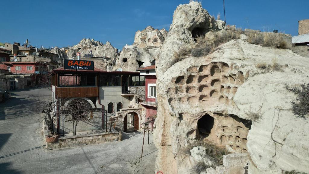 Babili Cappadocia Cave Hotel في نوشهر: مبنى على جانب جبل صخري