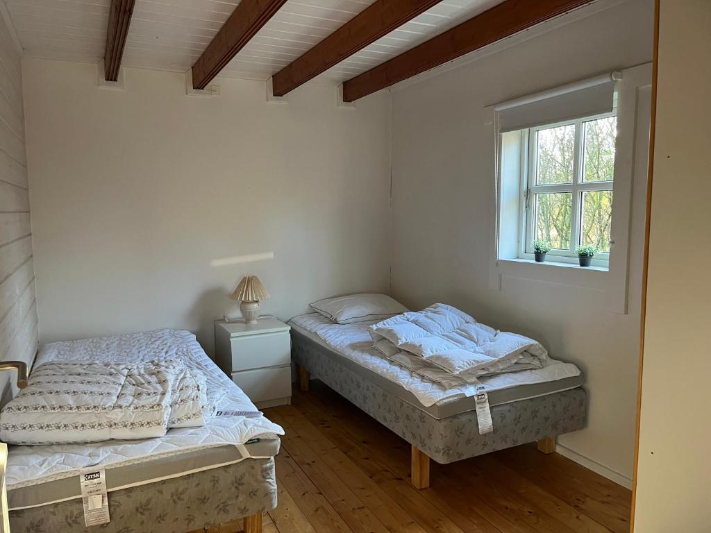 2 camas individuales en una habitación con ventana en Hovborg Ferieby - Torpet 126, en Hovborg