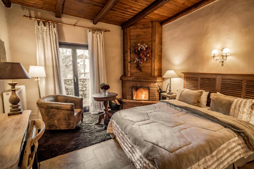 um quarto com uma cama, uma cadeira e uma lareira em Chalet Sapin Hotel em Palaios Agios Athanasios