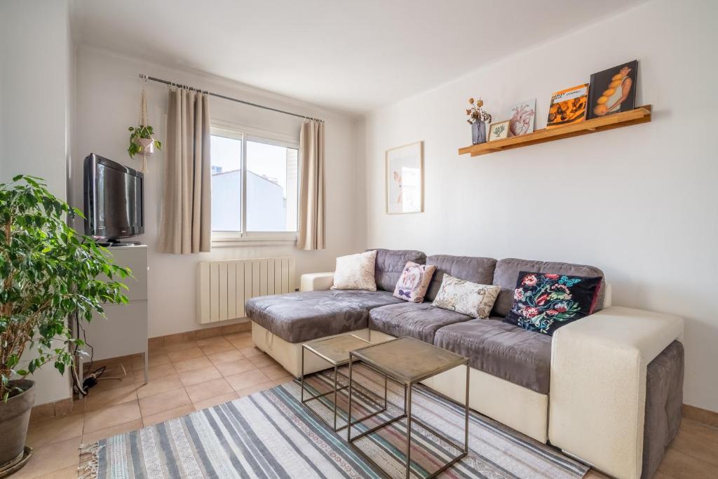 a living room with a couch and a tv at Apt lumineux et très cosy avec balcon by Weekome in Marseille