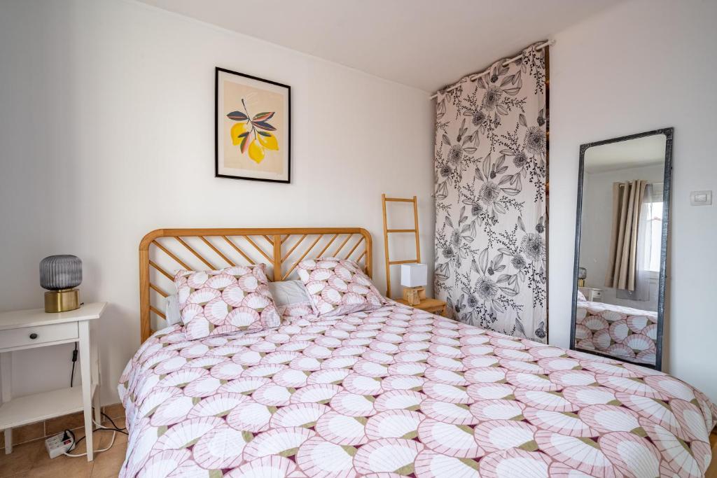 a bedroom with a large bed with a pink comforter at Apt lumineux et très cosy avec balcon by Weekome in Marseille