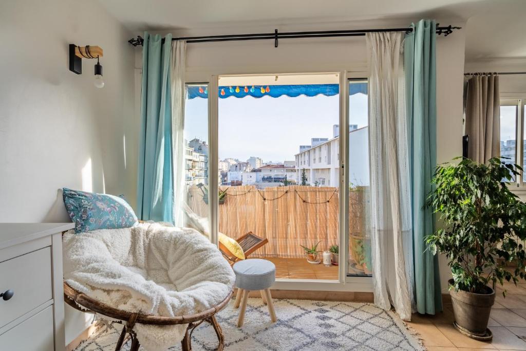 a room with a chair and a large window at Apt lumineux et très cosy avec balcon by Weekome in Marseille