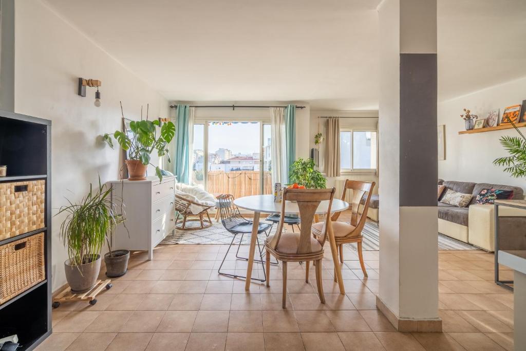 a kitchen and living room with a table and chairs at Apt lumineux et très cosy avec balcon by Weekome in Marseille