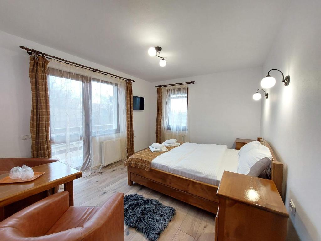 Schlafzimmer mit einem Bett, einem Schreibtisch und einem Fenster in der Unterkunft Casa Calea Haiducilor in Sohodol