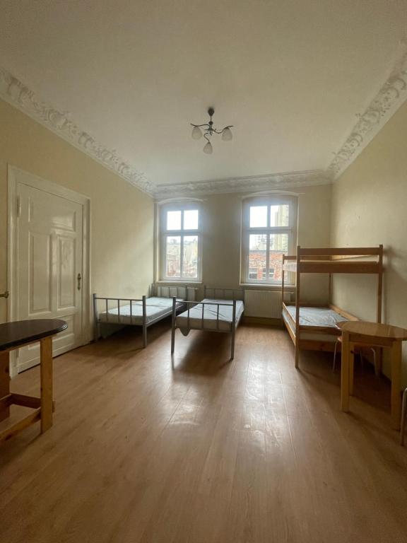 an empty room with two bunk beds and wooden floors at Kwatery pracownicze Bydgoszcz Centrum in Bydgoszcz