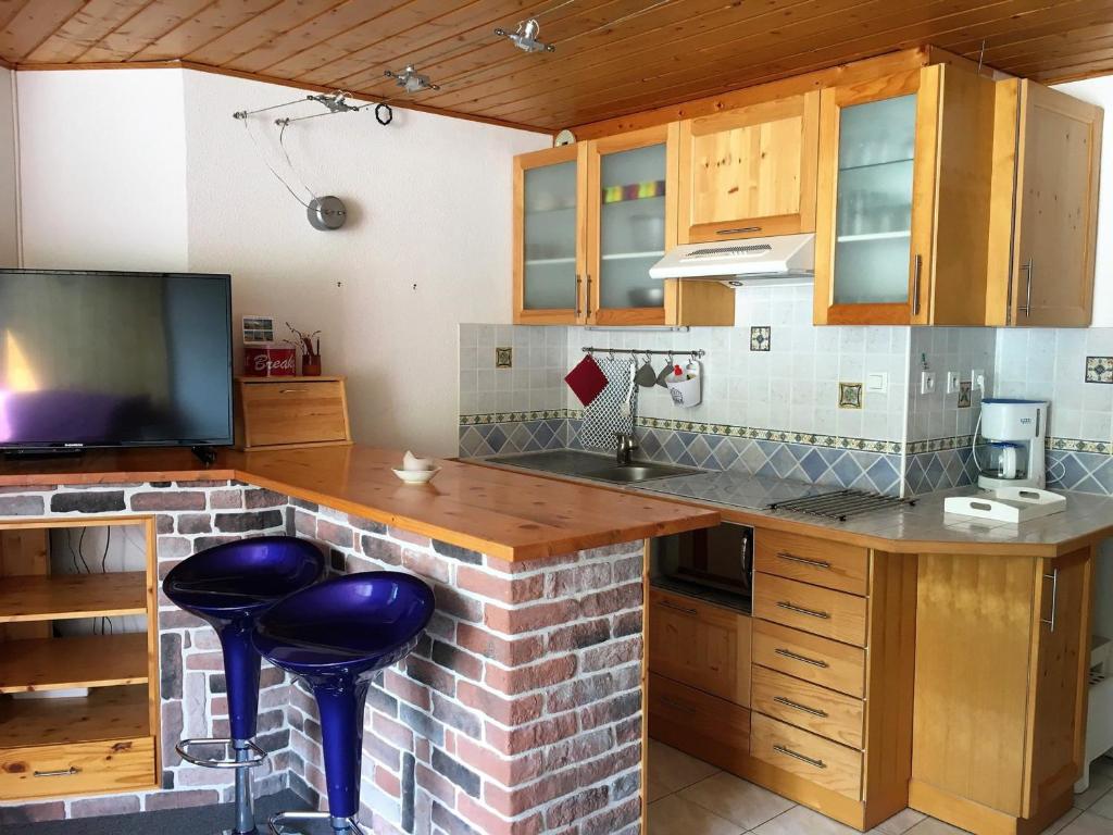 eine Küche mit Theke und TV in der Unterkunft Appartement La Joue du Loup, 2 pièces, 7 personnes - FR-1-504-76 in Le Dévoluy