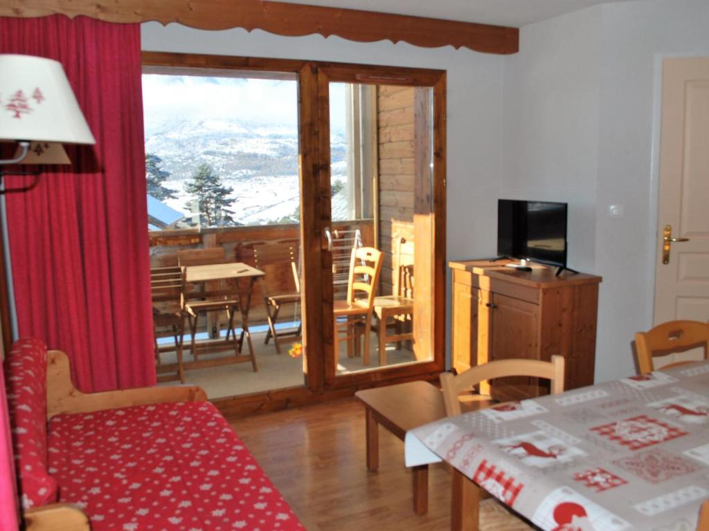 a living room with a sliding glass door with a balcony at Appartement La Joue du Loup, 2 pièces, 6 personnes - FR-1-504-86 in Le Dévoluy