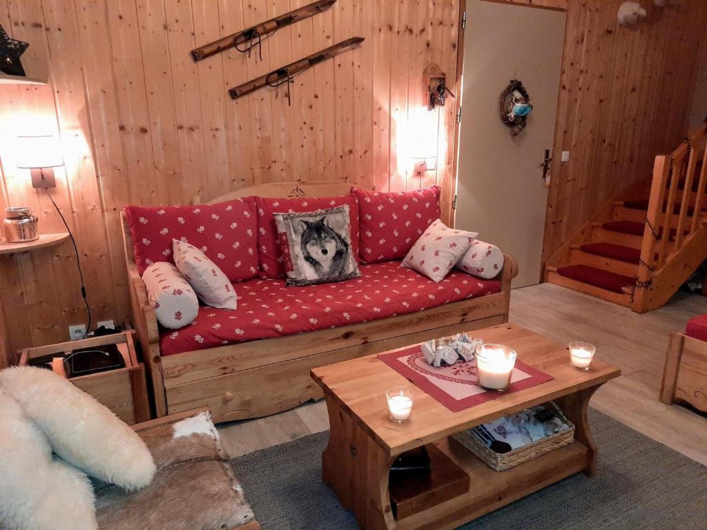 a living room with a red couch and a table at Chalet La Joue du Loup, 3 pièces, 6 personnes - FR-1-504-128 in Le Dévoluy