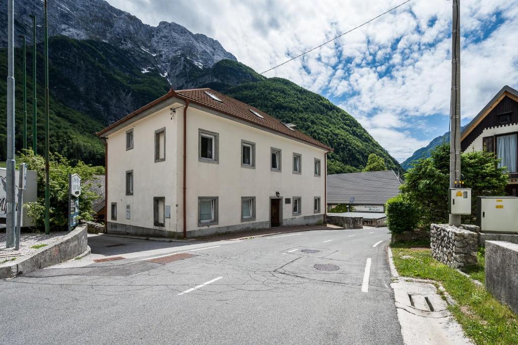 ein Gebäude an der Seite einer Straße mit einem Berg in der Unterkunft Hostel Kronotop in Triglav National Park in Log pod Mangartom