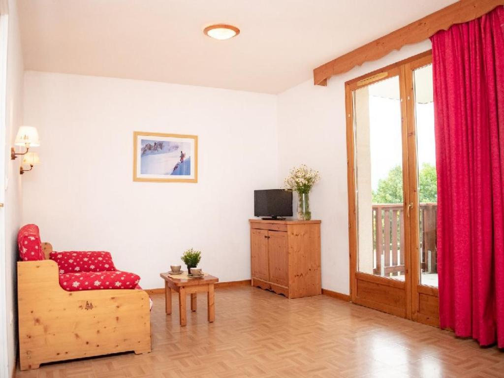 sala de estar con silla roja y puerta corredera de cristal en Appartement Puy-Saint-Vincent, 2 pièces, 4 personnes - FR-1-504-260, en Puy-Saint-Vincent