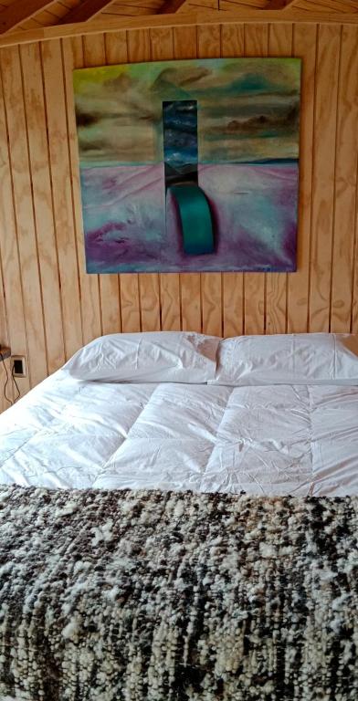 1 cama en un dormitorio con una pintura en la pared en Willipeuma en Yutuy