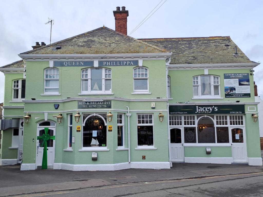 a green building on the corner of a street at Queen Phillippa in Queenborough