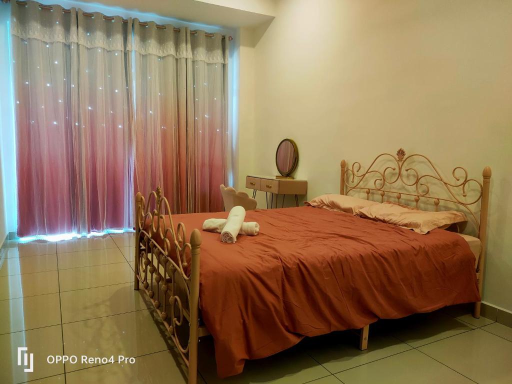 a bedroom with a bed with a red blanket and a window at Ngio Homestay Batu Pahat in Batu Pahat