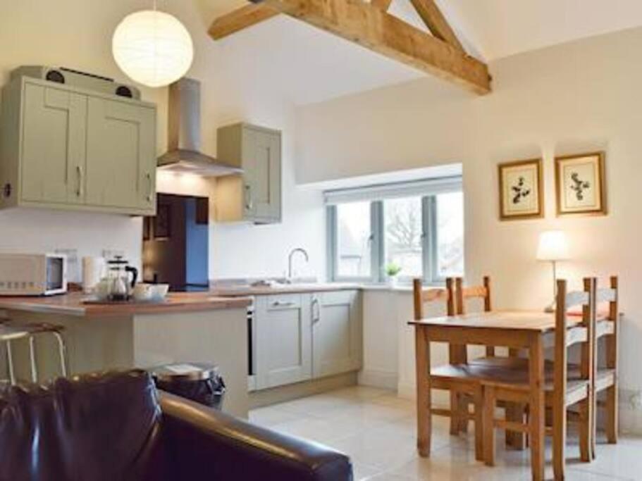 a kitchen and dining room with a table and chairs at Mole Hole in Towcester