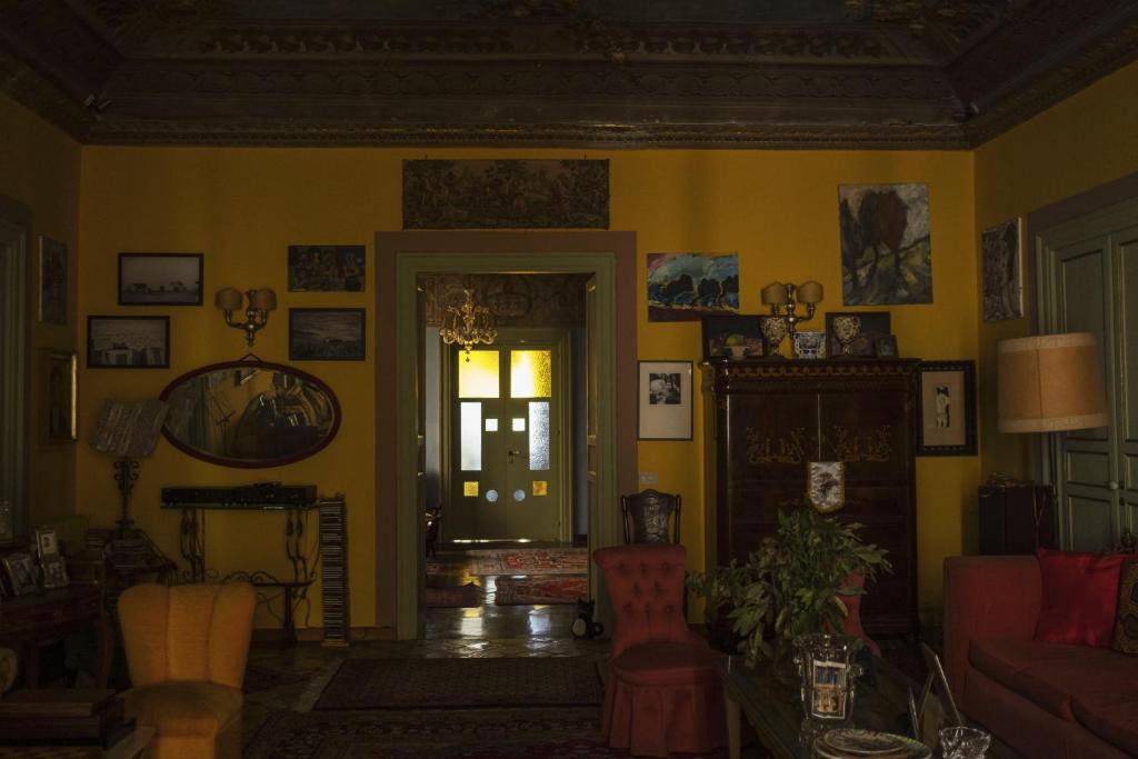 uma sala de estar com paredes amarelas e uma porta em La dimora del genio em Palermo
