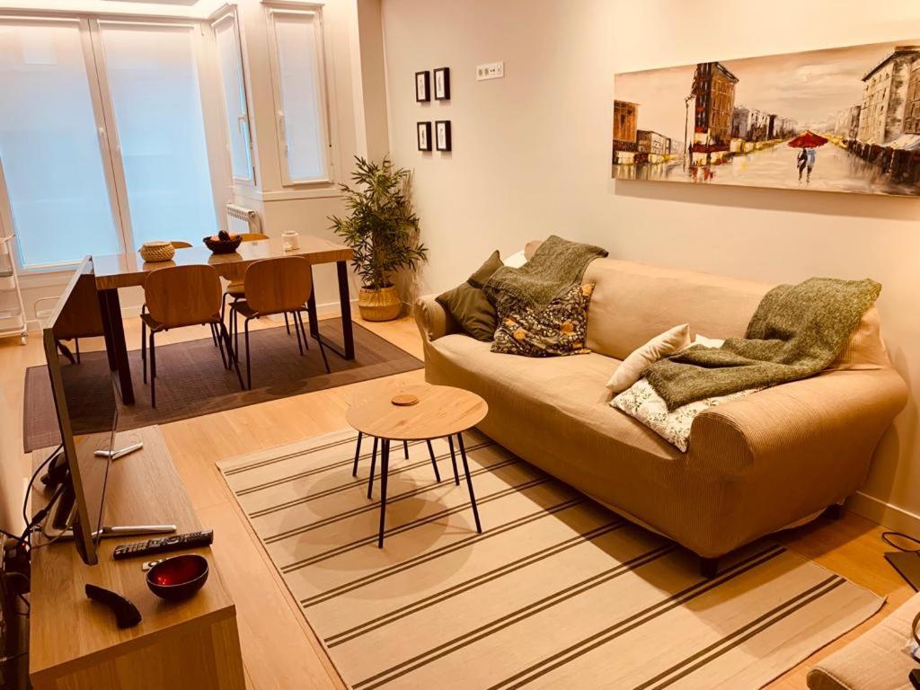 - un salon avec un canapé et une table dans l'établissement APARTAMENTO EL SOLARON, à Gijón