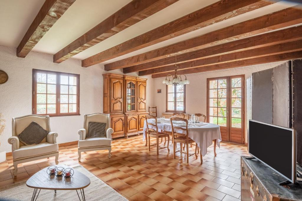 a living room with a table and chairs and a tv at L'Espedes in Ruoms