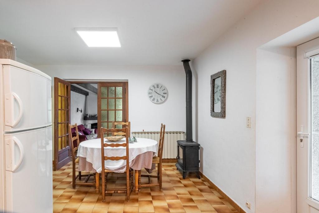 a dining room with a table and a clock on the wall at L&#39;Espedes in Ruoms