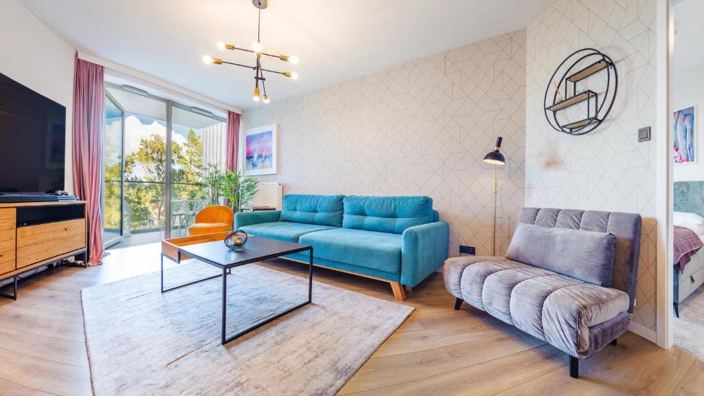 un soggiorno con divano blu e TV di Apartamenty Sun & Snow Pinea a Pobierowo