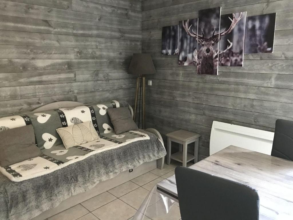 Cette chambre comprend un lit avec des oreillers et une table. dans l'établissement Chalet rénové 7 pers, 2 chambres, parking, animaux admis - FR-1-504-68, à Saint-Étienne-en-Dévoluy