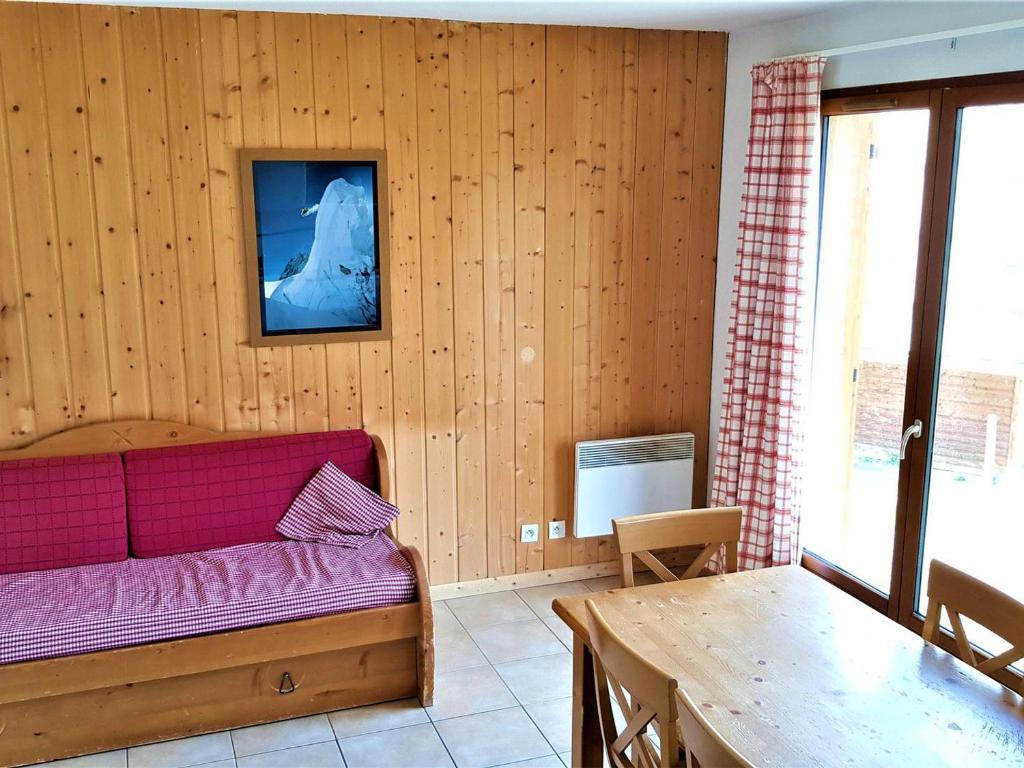 een woonkamer met een paarse bank en een tafel bij Chalet La Joue du Loup, 4 pièces, 8 personnes - FR-1-504-40 in Le Dévoluy