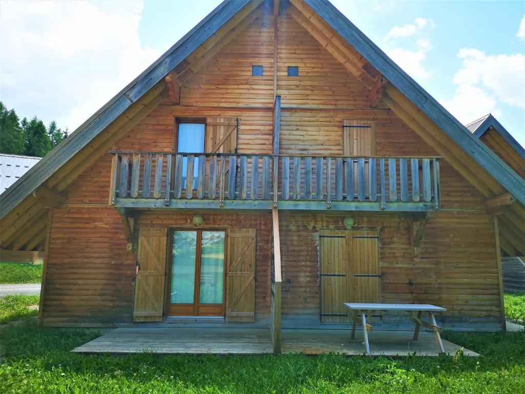Cette cabane en rondins dispose d'un balcon et d'une table de pique-nique. dans l'établissement Chalet 3 pièces à La Joue du Loup avec parking, 7 personnes - FR-1-504-45, à Saint-Étienne-en-Dévoluy