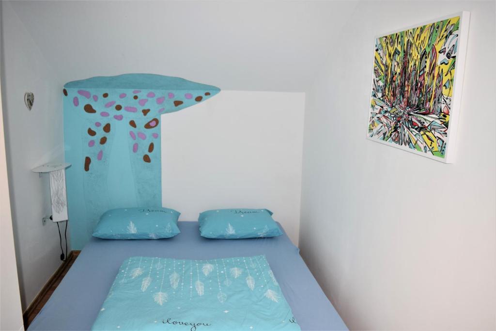 Un dormitorio con una cama azul con una pintura en la pared en Art nature, Belgrade, Medak, en Voždivac