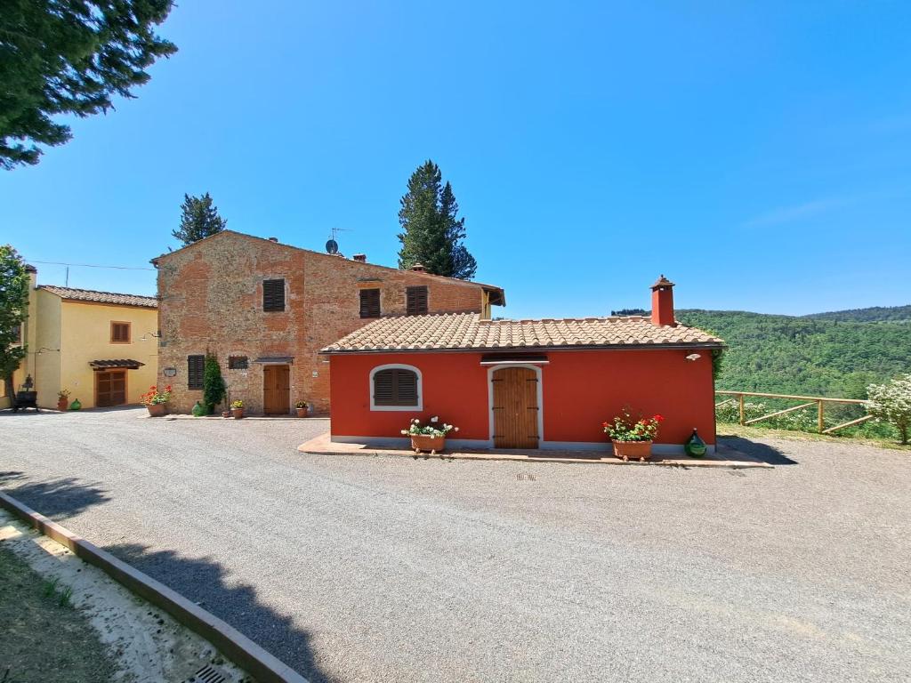 una casa roja al lado de una carretera en Agriturismo Poggio Nardini en San Donato a Livizzano
