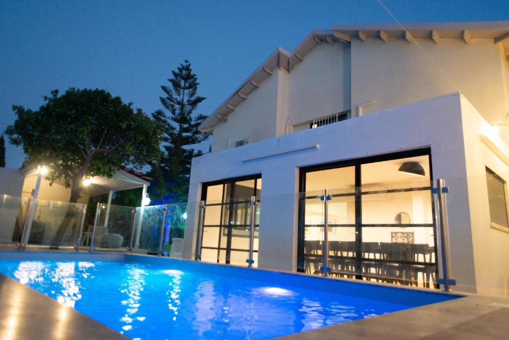 a villa with a swimming pool at night at הבית ברחוב הרמבם in Qiryat Shemona