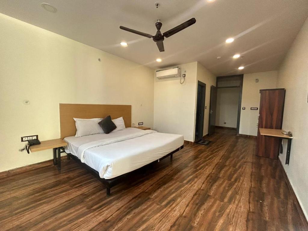 - une chambre avec un lit et un ventilateur de plafond dans l'établissement The Chaitanya United Stay, à New Delhi