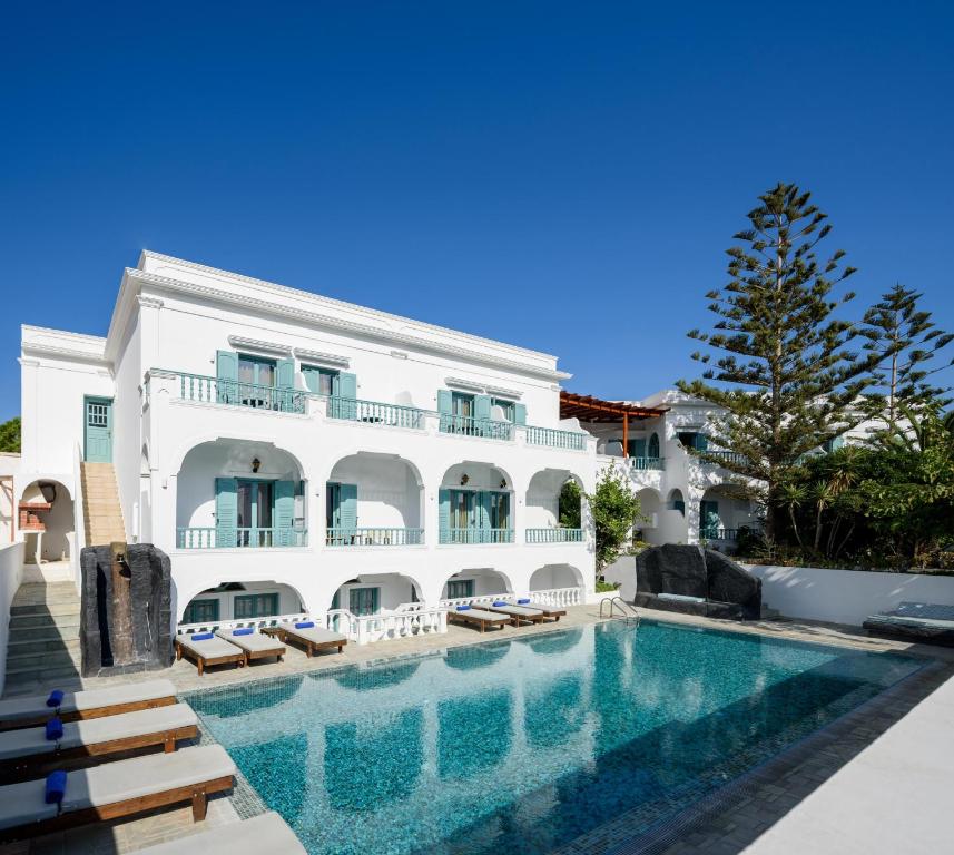 a hotel with a swimming pool in front of a building at Armonia in Kamari