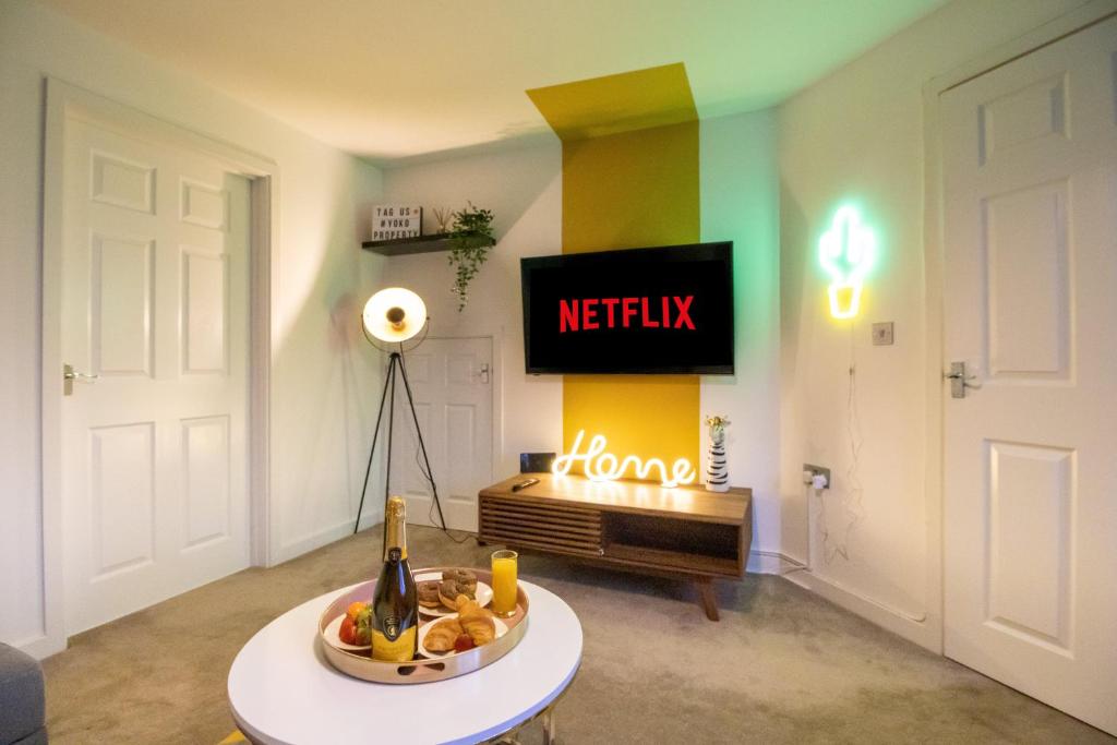 a living room with a tv and a table with fruit at The Cosy House with Free Parking, Garden and Smart TV with Netflix by Yoko Property - Perfect for Contractors, Groups & Relocation in Leamington Spa