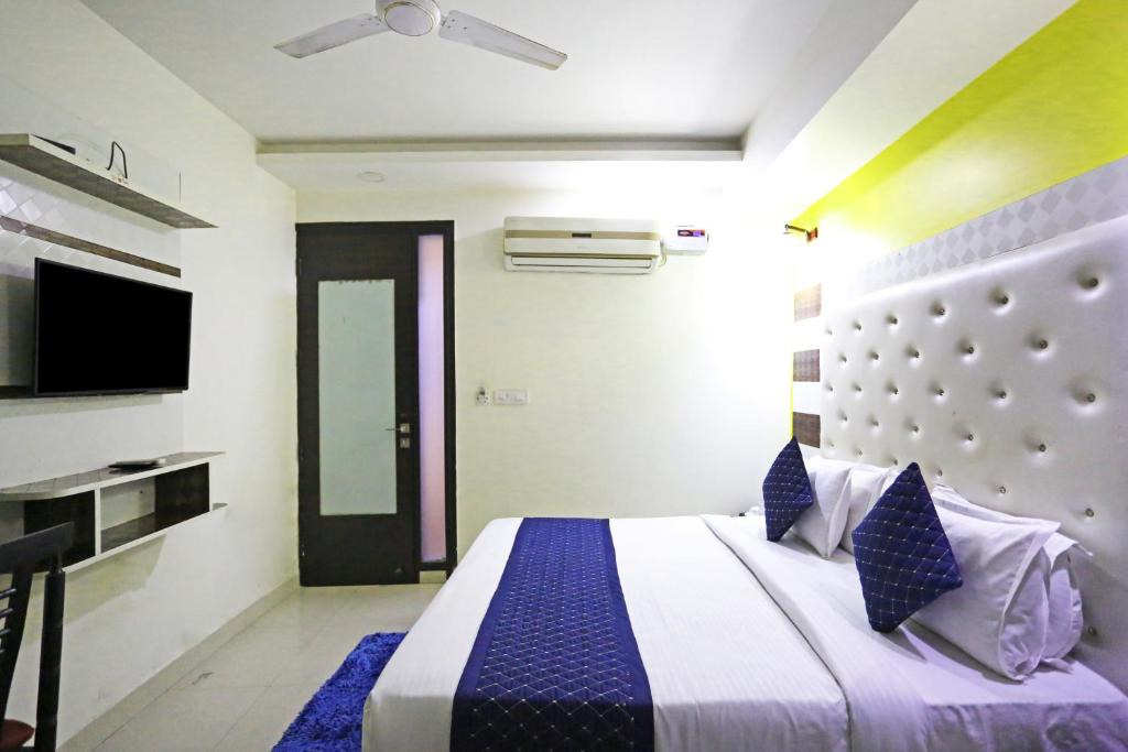a bedroom with a large bed and a tv at Hotel Smart Inn Near Delhi Airport in New Delhi