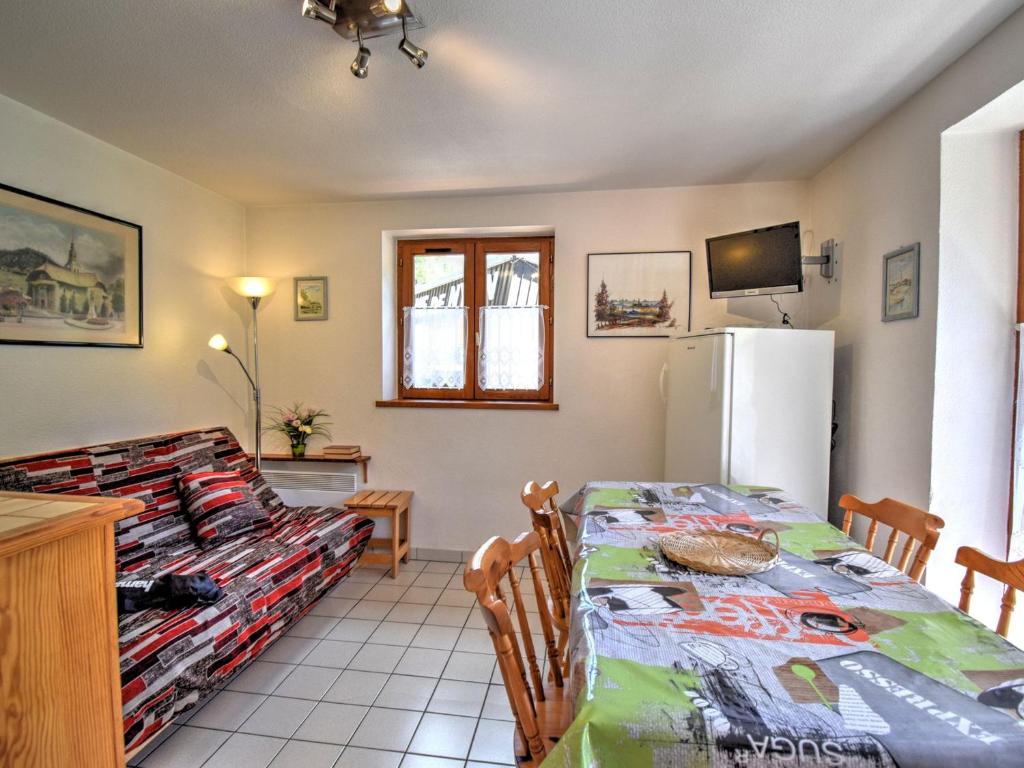 une cuisine et une salle à manger avec une table et un réfrigérateur dans l'établissement Appartement cosy au pied du téléphérique de Nyon, balcon, parking, animaux admis - FR-1-524-19, à Morzine