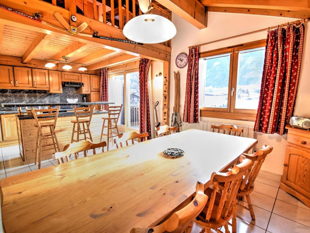 une salle à manger et une cuisine avec une table et des chaises dans l'établissement Appart duplex familial avec mezzanine, 200m du centre et remontées, équipé pour 8, parking, WiFi - FR-1-524-10, à Morzine