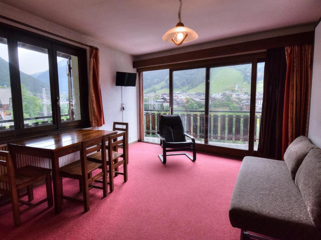 - un salon avec une table, des chaises et de grandes fenêtres dans l'établissement Appartement familial à Morzine avec parking et Wi-Fi - FR-1-524-37, à Morzine