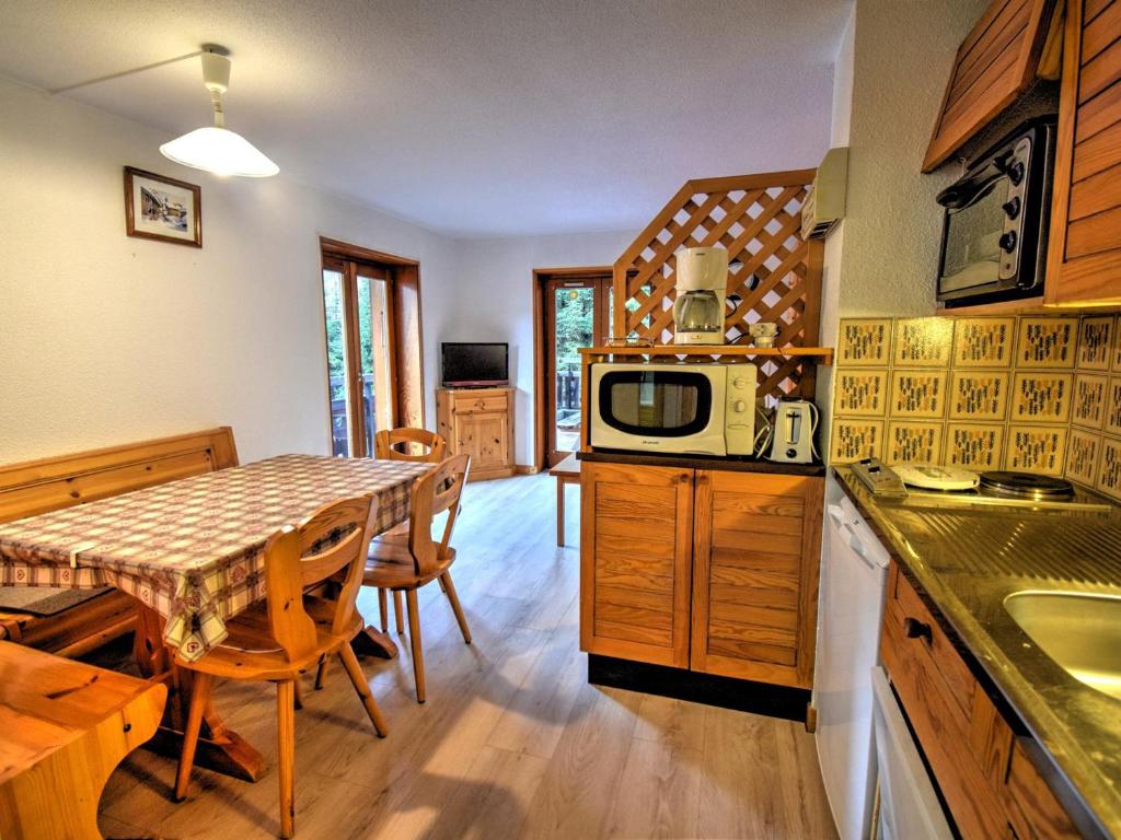 - une cuisine et une salle à manger avec une table et un four micro-ondes dans l'établissement Bel appartement rénové proche centre de Morzine avec parking - FR-1-524-57, à Morzine