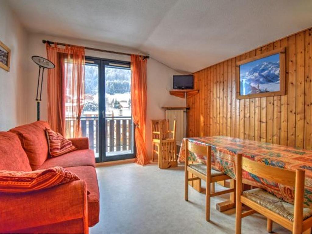 un salon avec un canapé rouge et une table dans l'établissement Appartement 2 pièces près du centre de Morzine avec balcon et parking, animaux admis - FR-1-524-44, à Morzine