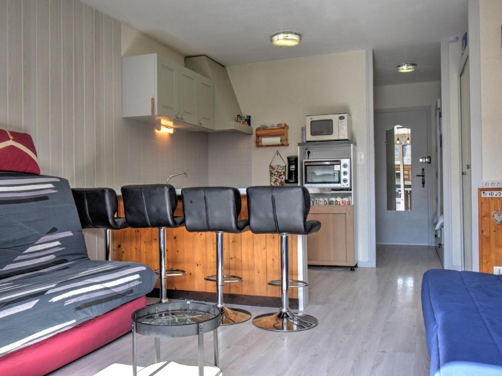 ein Wohnzimmer mit einem Sofa und einigen Barhockern in der Unterkunft Studio Morzine, 1 pièce, 6 personnes - FR-1-524-104 in Morzine