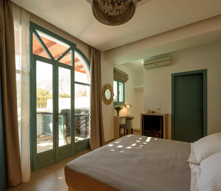 a bedroom with a bed and a large window at Armonia in Kamari
