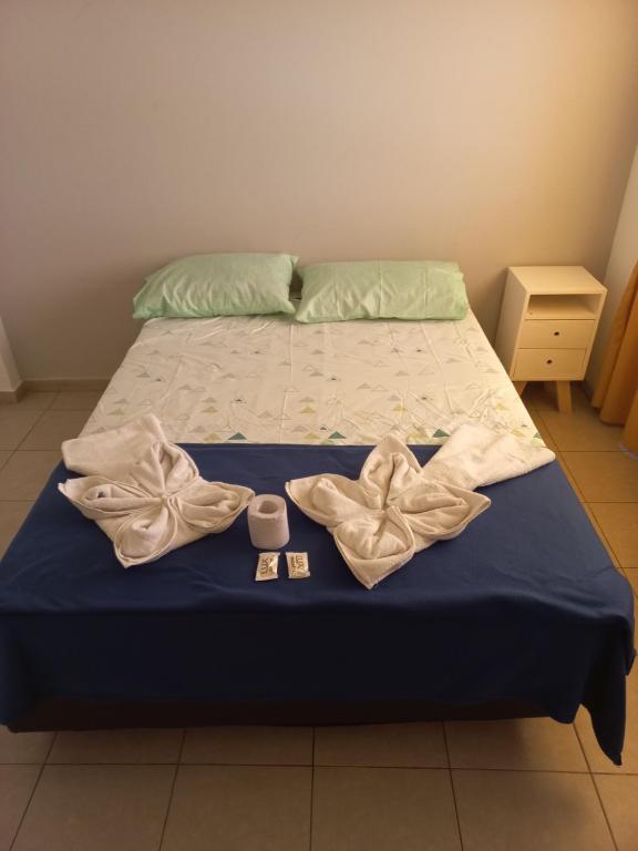 a bed with two towels and a cup on it at Hotel CBA in Cordoba