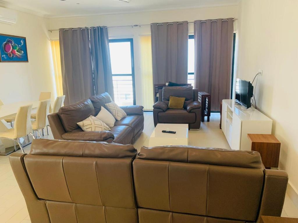 ein Wohnzimmer mit einem Sofa und 2 Stühlen in der Unterkunft Relax Serviced Ocean 3bedroom Beach Front House in Bijilo