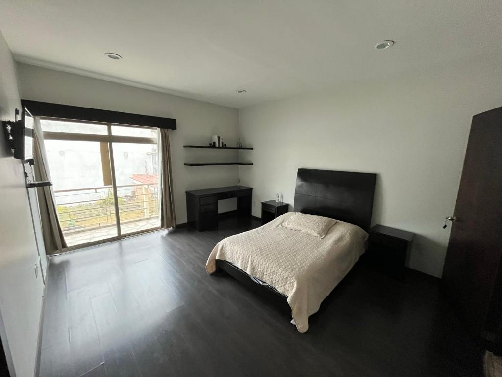 a bedroom with a bed and a large window at Habitación Ojo de Agua in Orizaba