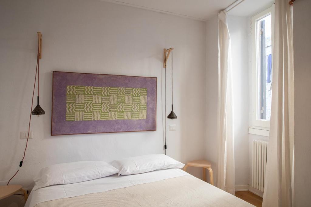 1 dormitorio con 1 cama y una pintura en la pared en Loft nel borgo, en Bracciano