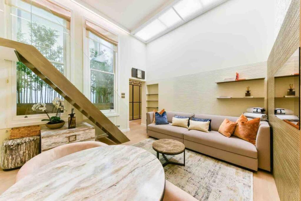 een woonkamer met een bank en een tafel bij Luxury Modern Apartment in Londen